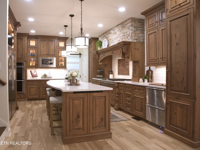 kitchen with a kitchen island, stainless steel appliances, decorative backsplash, light countertops, and a kitchen bar