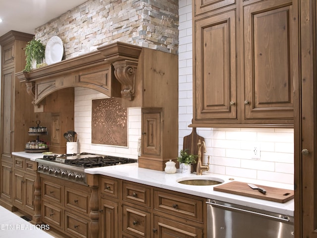 kitchen featuring a sink, tasteful backsplash, appliances with stainless steel finishes, and brown cabinetry