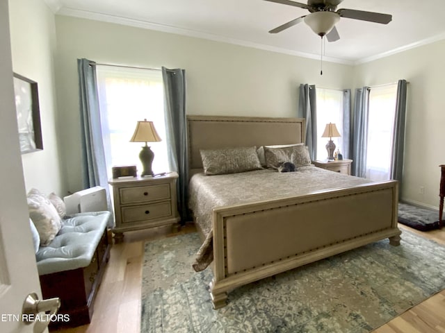 bedroom with ceiling fan, wood finished floors, and ornamental molding