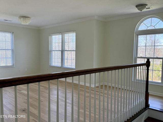 hallway with wood finished floors and ornamental molding