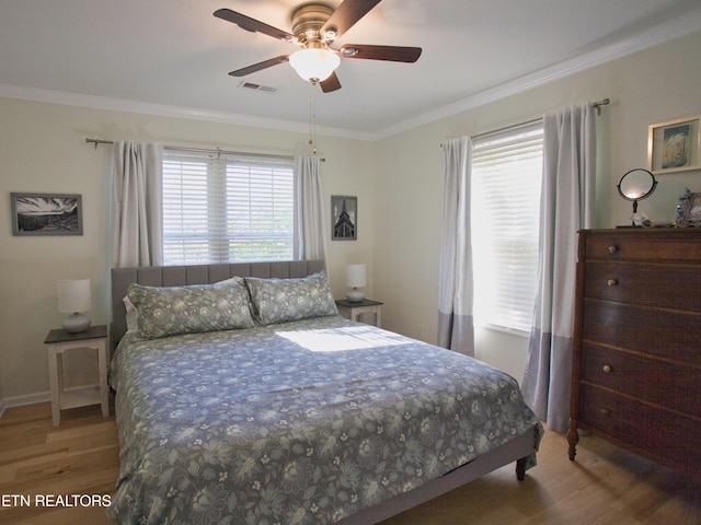 bedroom featuring visible vents, wood finished floors, baseboards, and ornamental molding