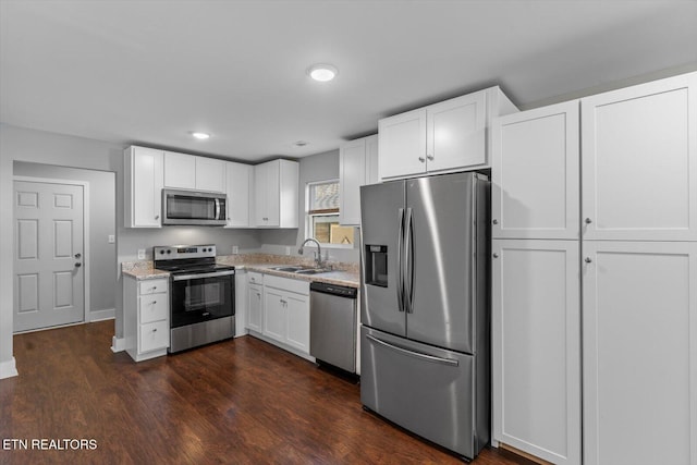 kitchen featuring a sink, dark wood-type flooring, appliances with stainless steel finishes, and white cabinetry