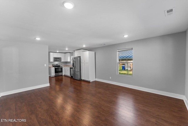 unfurnished living room with visible vents, recessed lighting, baseboards, and dark wood-style flooring