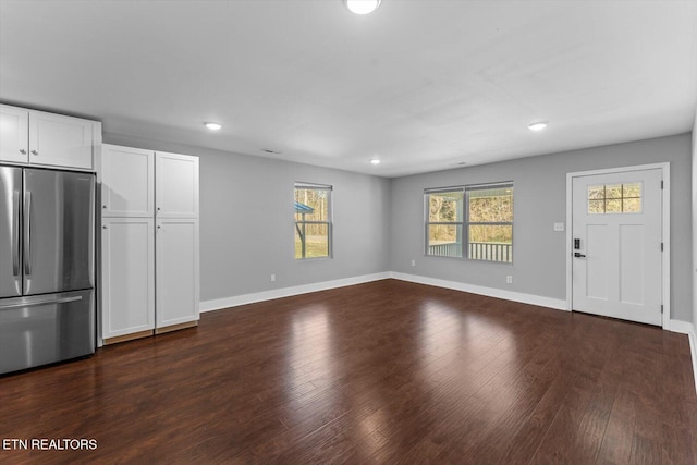 unfurnished living room featuring recessed lighting, baseboards, and dark wood-style flooring