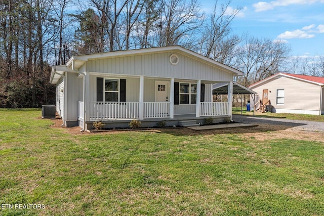 view of front of property with covered porch, cooling unit, and a front yard