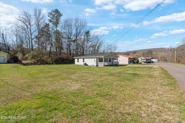 view of front of house with covered porch, driveway, and a front yard