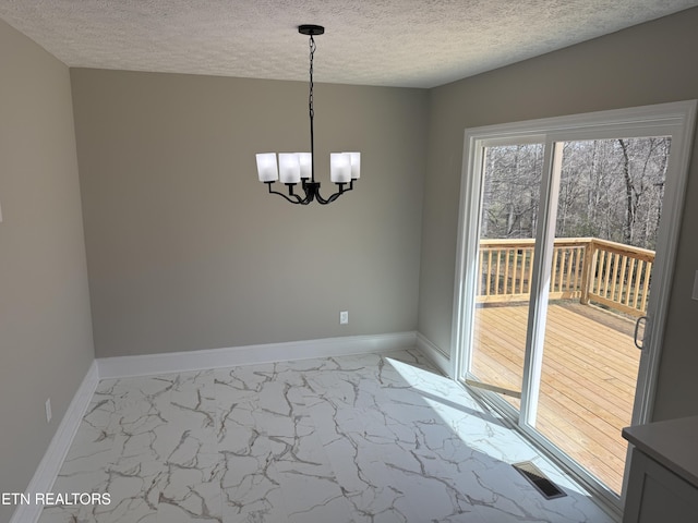 unfurnished dining area with marble finish floor, an inviting chandelier, and baseboards