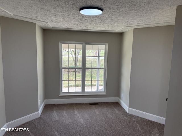 carpeted spare room featuring visible vents, a textured ceiling, and baseboards