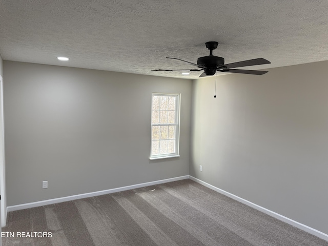 carpeted empty room with a textured ceiling, baseboards, and ceiling fan