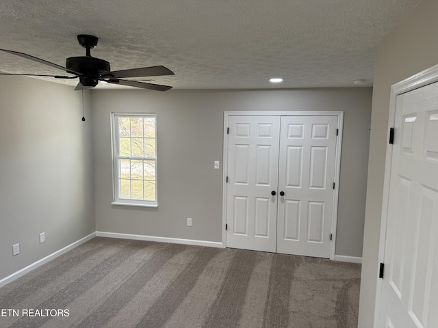 unfurnished bedroom featuring a closet, baseboards, carpet floors, and a textured ceiling