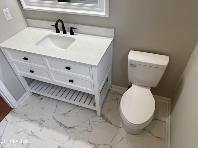 bathroom with baseboards, toilet, marble finish floor, and vanity