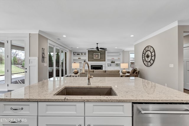 kitchen with ornamental molding, a ceiling fan, a sink, open floor plan, and dishwasher