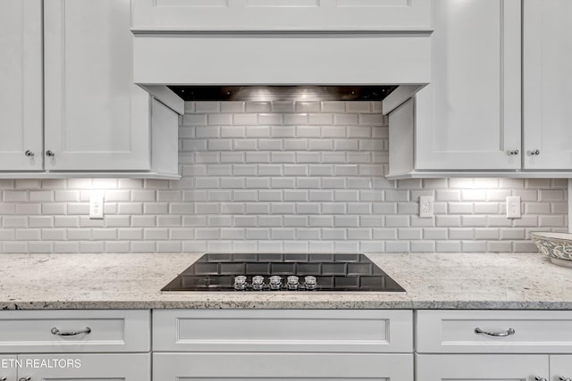 kitchen with tasteful backsplash, white cabinets, and black electric cooktop