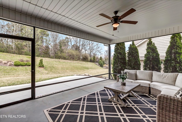 unfurnished sunroom featuring a ceiling fan and a healthy amount of sunlight