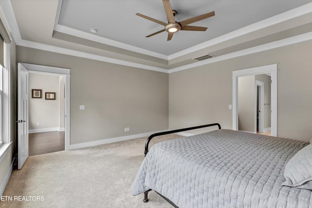 bedroom with a raised ceiling, carpet flooring, baseboards, and visible vents