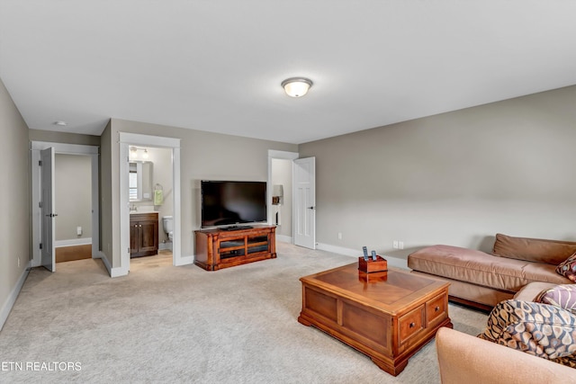 living area with baseboards and light colored carpet