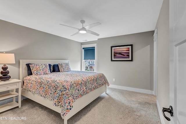 carpeted bedroom with a ceiling fan and baseboards