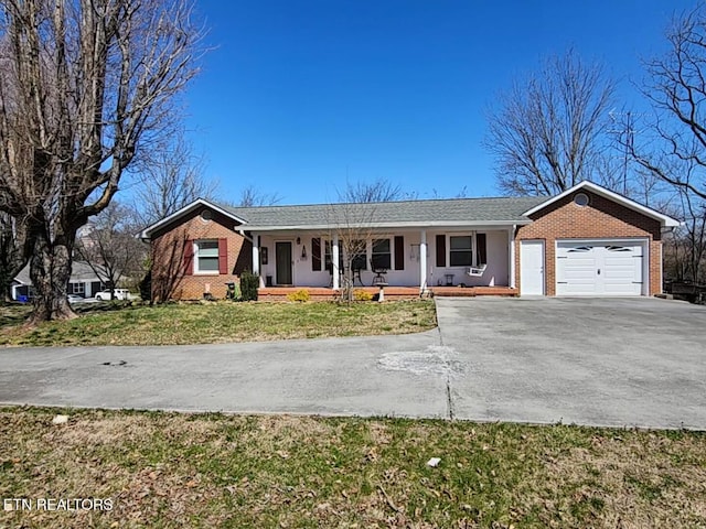 single story home with brick siding, a porch, concrete driveway, and an attached garage