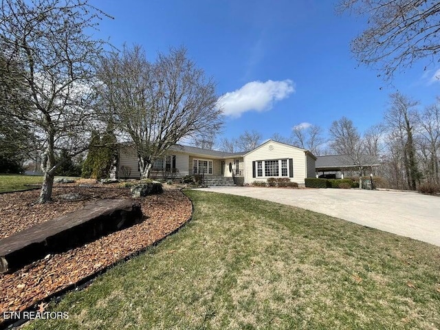 ranch-style house featuring driveway and a front lawn