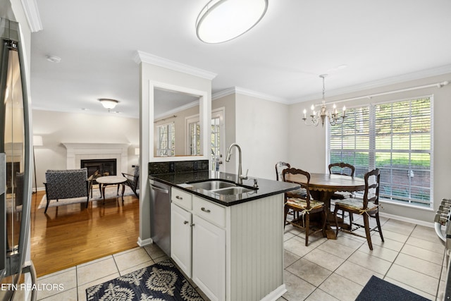 5633 Eagle Crest Ln, Knoxville, TN 37921 - kitchen featuring a sink, appliances with stainless steel finishes, a chandelier, a fireplace, and light tile patterned flooring