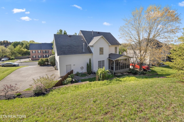 5633 Eagle Crest Ln, Knoxville, TN 37921 - back of property featuring a sunroom, a shingled roof, a yard, and concrete driveway