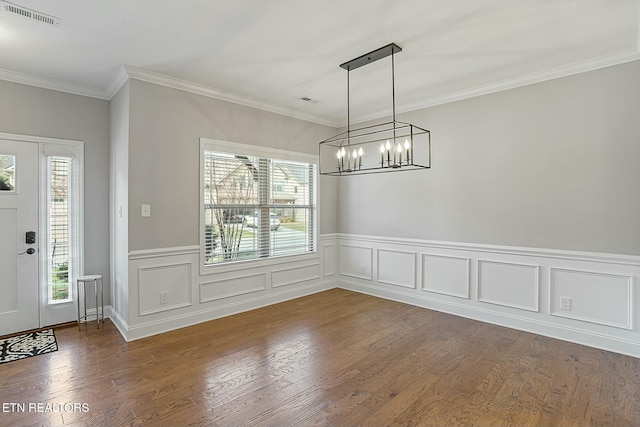 unfurnished dining area with an inviting chandelier, plenty of natural light, wood finished floors, and visible vents