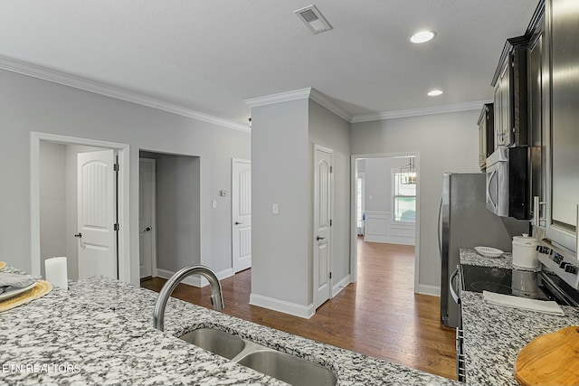 kitchen with light stone counters, visible vents, dark wood finished floors, and a sink