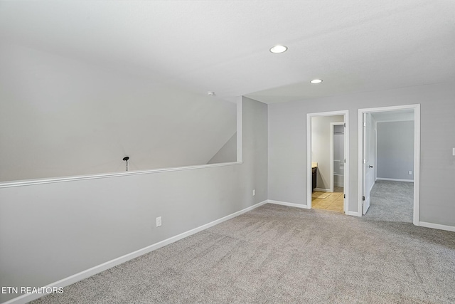 carpeted empty room featuring recessed lighting and baseboards