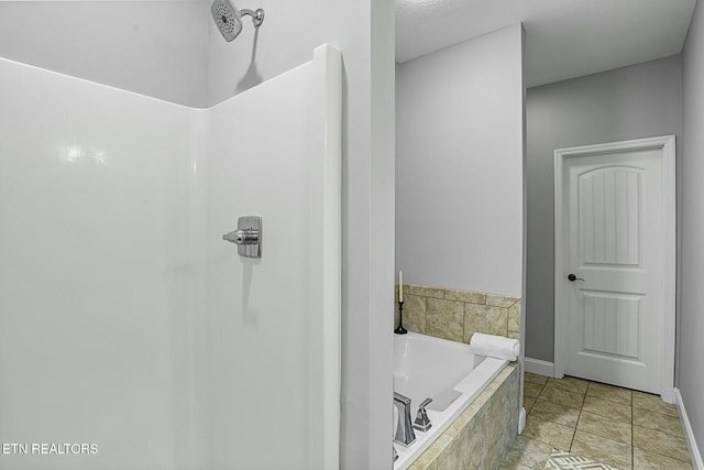 bathroom with a bath, tile patterned flooring, baseboards, and walk in shower