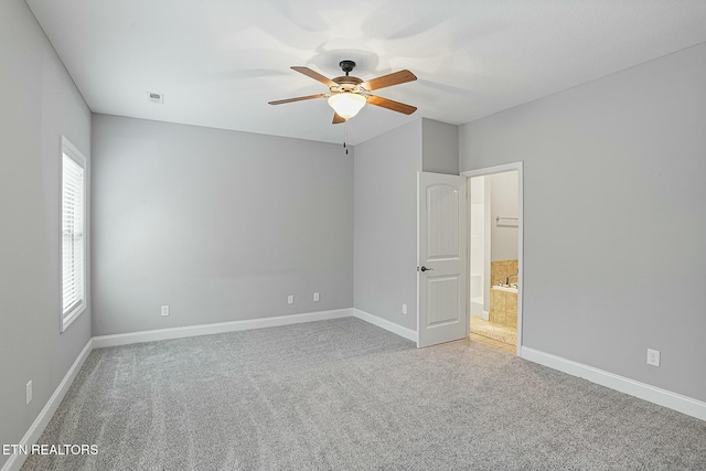 empty room featuring light carpet, visible vents, baseboards, and ceiling fan