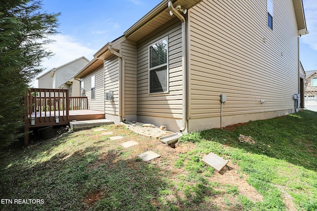 view of side of property with a lawn and a deck