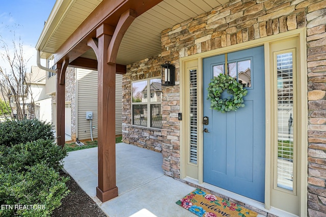 property entrance with stone siding and covered porch