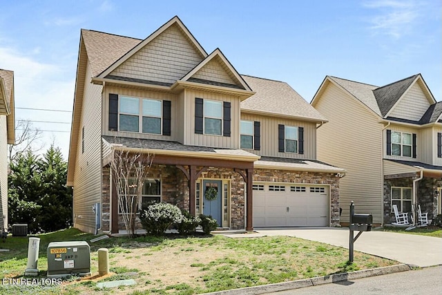 view of front of property featuring driveway, a garage, stone siding, central air condition unit, and board and batten siding