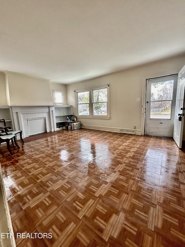 unfurnished living room with baseboards, a healthy amount of sunlight, and a fireplace