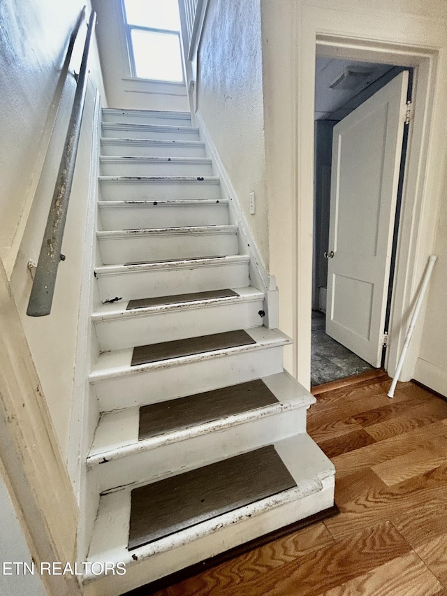 stairs featuring wood finished floors