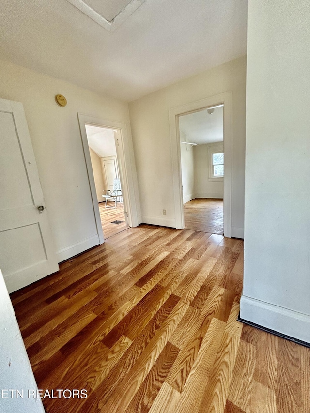 unfurnished room featuring baseboards and light wood finished floors