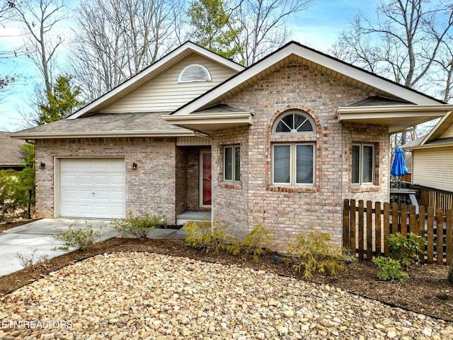 view of front facade featuring brick siding, a shingled roof, fence, a garage, and driveway