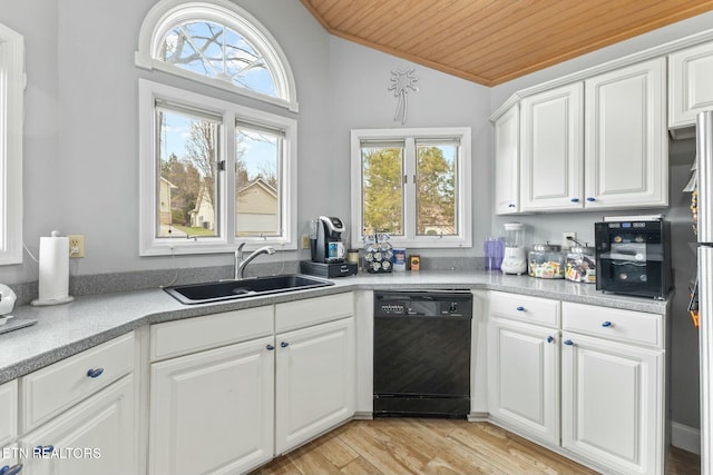 kitchen featuring light wood finished floors, lofted ceiling, a sink, white cabinets, and dishwasher