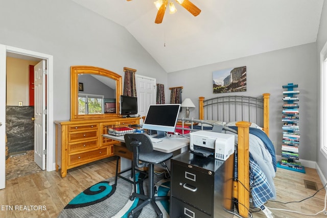 office featuring visible vents, ceiling fan, baseboards, vaulted ceiling, and light wood-style floors