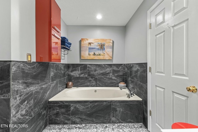 full bath featuring tile walls and a bath