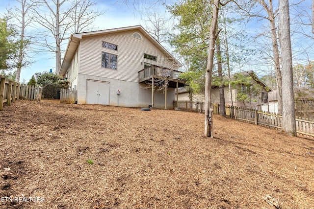 rear view of property with a deck and a fenced backyard