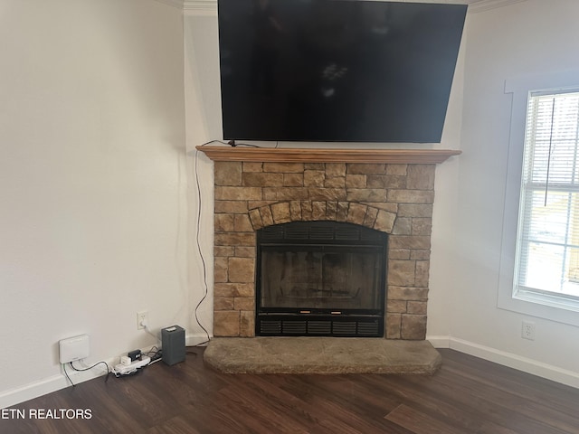 interior details with a glass covered fireplace, baseboards, and wood finished floors