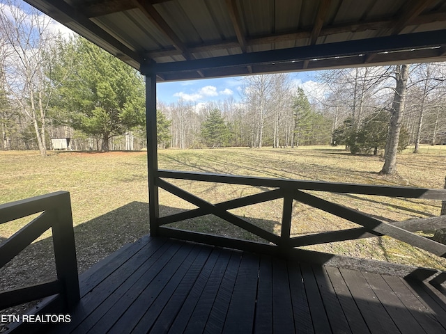 wooden deck featuring a lawn