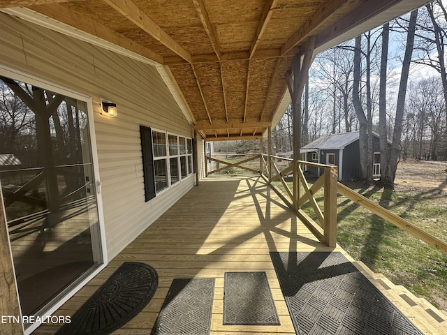 wooden deck with an outbuilding and a storage unit