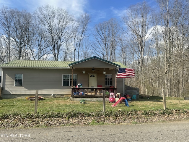 view of front of house with metal roof, a porch, and a front lawn