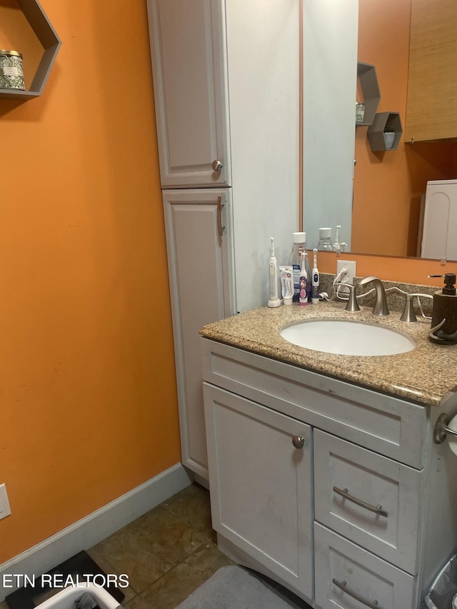 bathroom with tile patterned floors, baseboards, and vanity