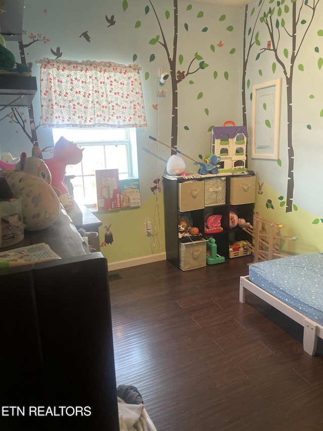 bedroom with baseboards and wood finished floors