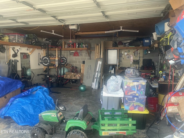 garage featuring a workshop area, a garage door opener, and concrete block wall