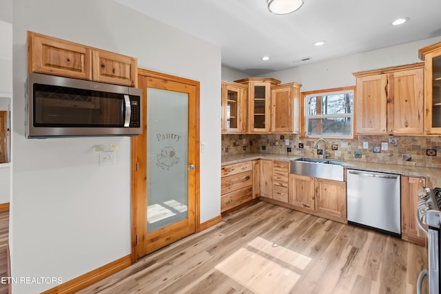 285 Redwood Dr, Dandridge, TN 37725 - kitchen with appliances with stainless steel finishes, light wood finished floors, tasteful backsplash, light stone counters, and glass insert cabinets
