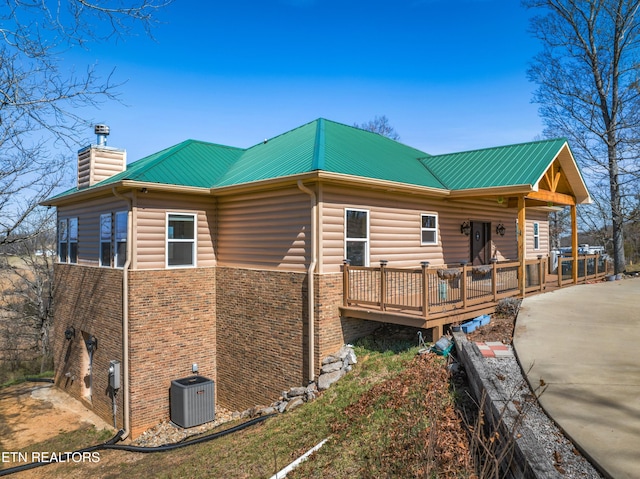 285 Redwood Dr, Dandridge, TN 37725 - view of home's exterior featuring a chimney, brick siding, a wooden deck, and a metal roof